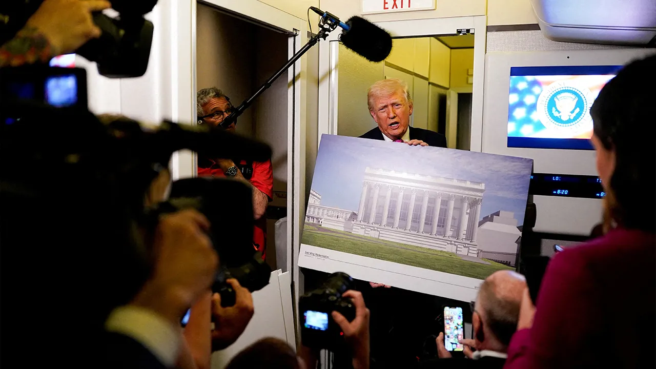 U.S. President Donald Trump talks to members of the media while holding up renderings of the planned White House ballroom, aboard Air Force One en route to Joint Base Andrews, Maryland, U.S., March 29, 2026. REUTERS/Elizabeth Frantz