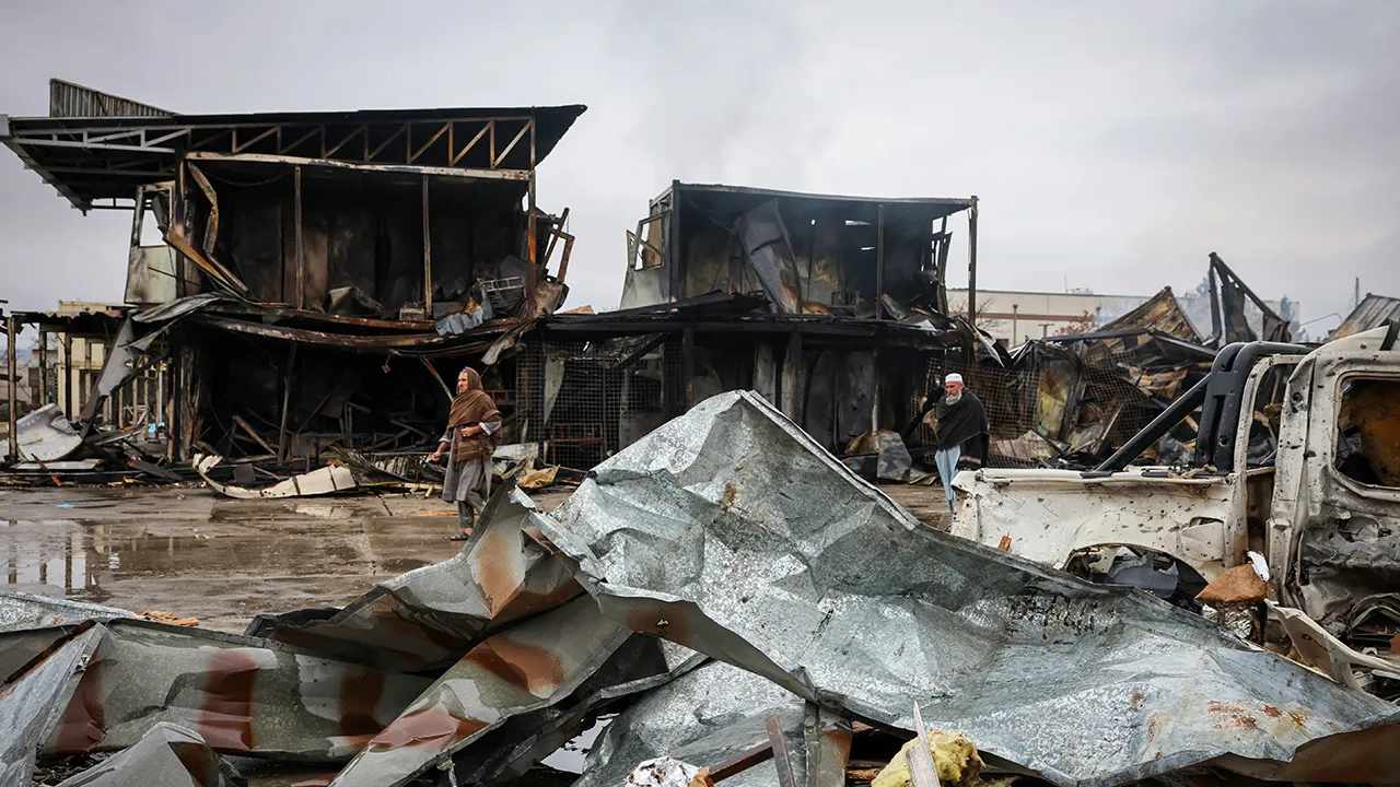 Afghan men walk next to debris lying at the site of a drug rehabilitation center destroyed in what the Taliban said was a Pakistani air strike in Kabul, Afghanistan, March 18, 2026. REUTERS/Sayed Hassib