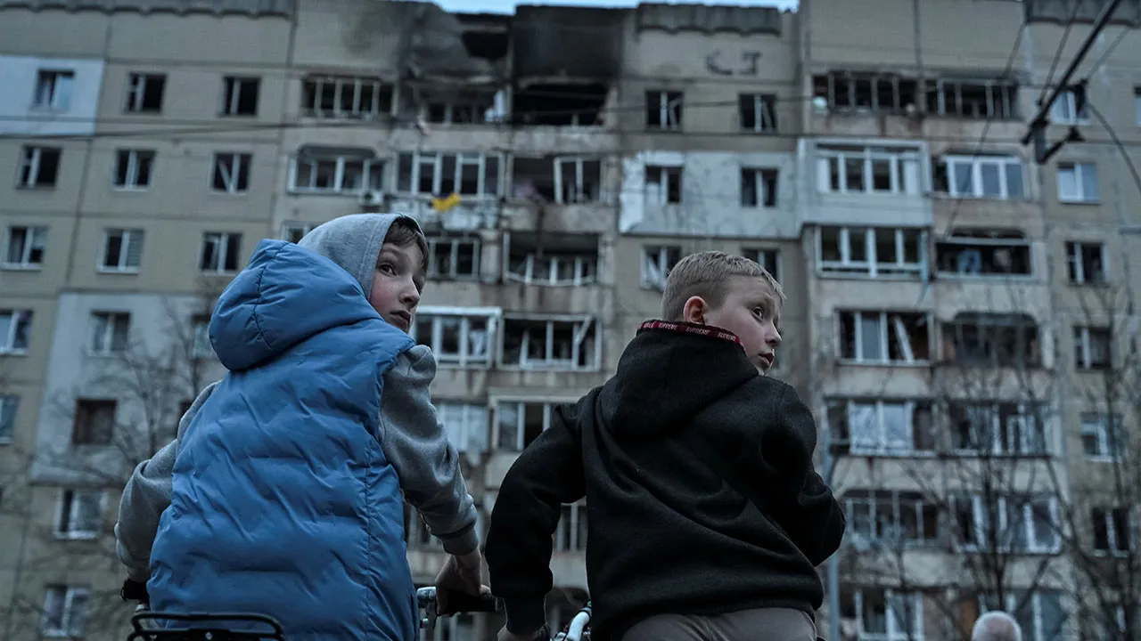 Boys on bicycles stand at the site of an apartment building hit by a Russian drone strike, amid Russia's attack on Ukraine, in central Lviv, Ukraine, March 24, 2026. REUTERS/Anastasiia Smolienko TPX IMAGES OF THE DAY