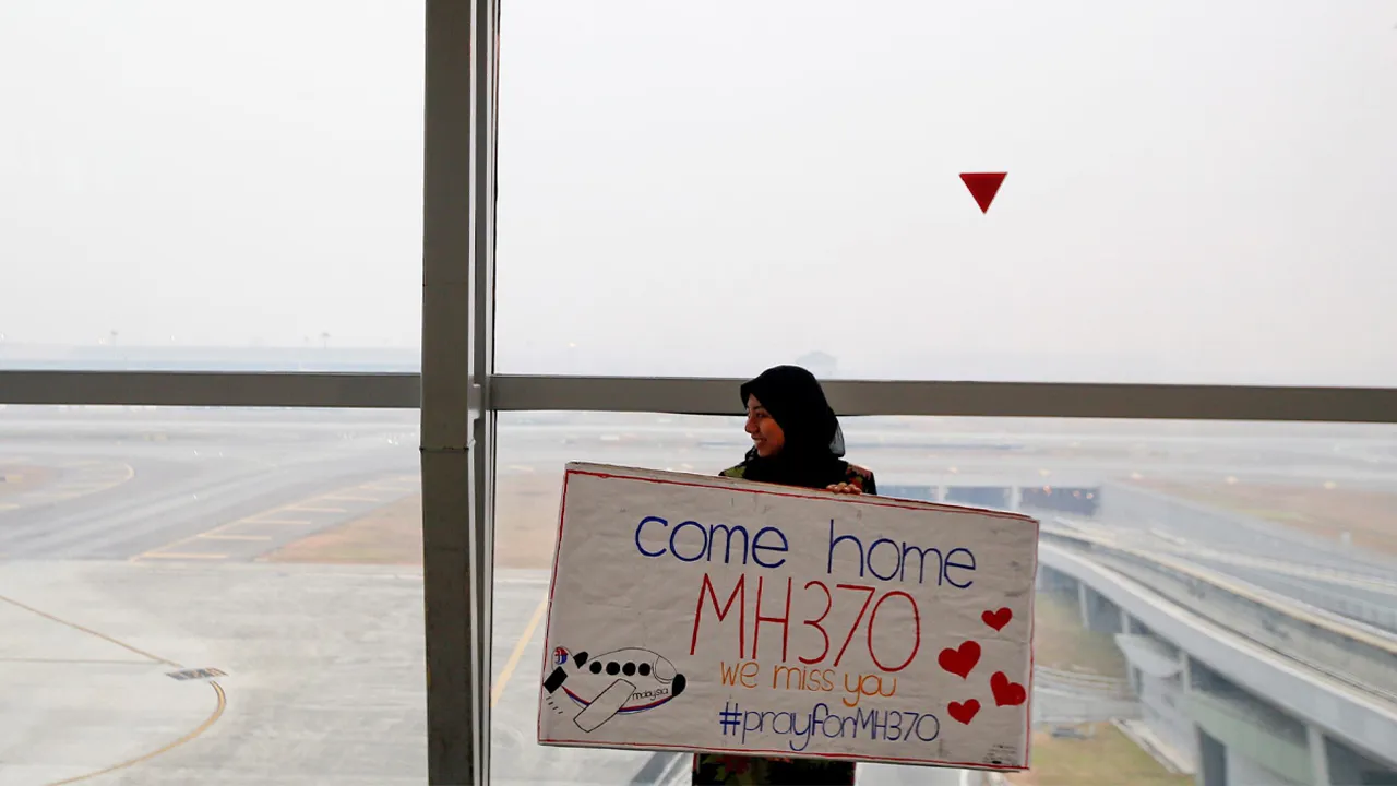 [1/6]FILE PHOTO: A woman holds a sign of support and hope for the passengers of the missing Malaysia Airlines flight MH370 she made and brought to the Kuala Lumpur International Airport March 11, 2014. REUTERS/Damir Sagolj/File Photo Purchase Licensing Rights