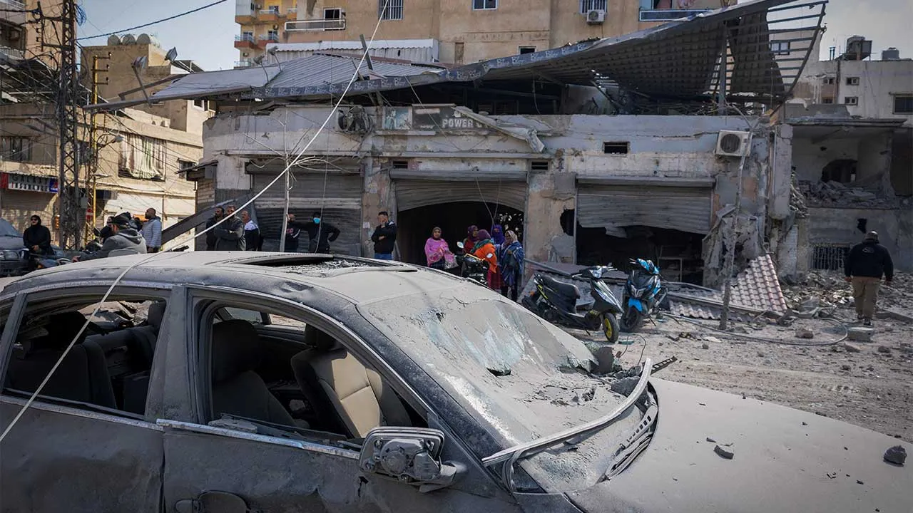 People stand next to a damaged building at the site of an Israeli strike in Tyre, Lebanon, April 8, 2026. REUTERS/Adnan Abidi