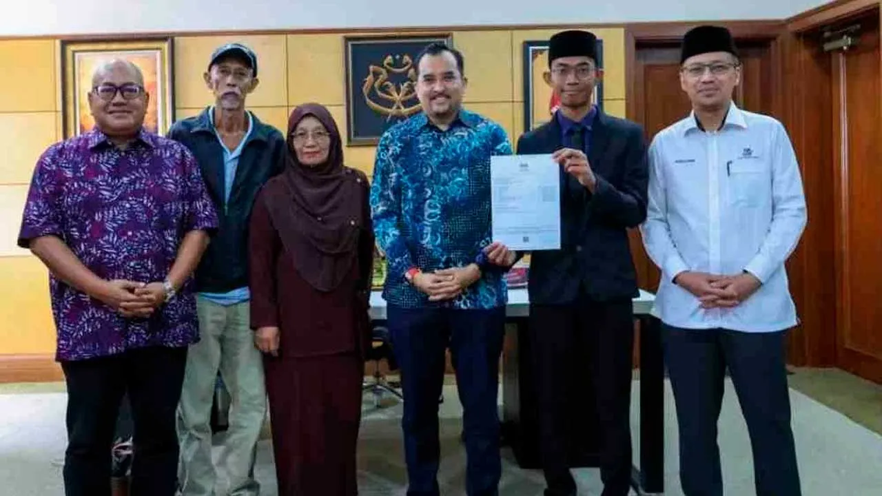 Fakhrul bersama kedua ibu bapanya bergambar bersama Asyraf Wajdi ketika mengunjungi Pengerusi Mara berkenaan.