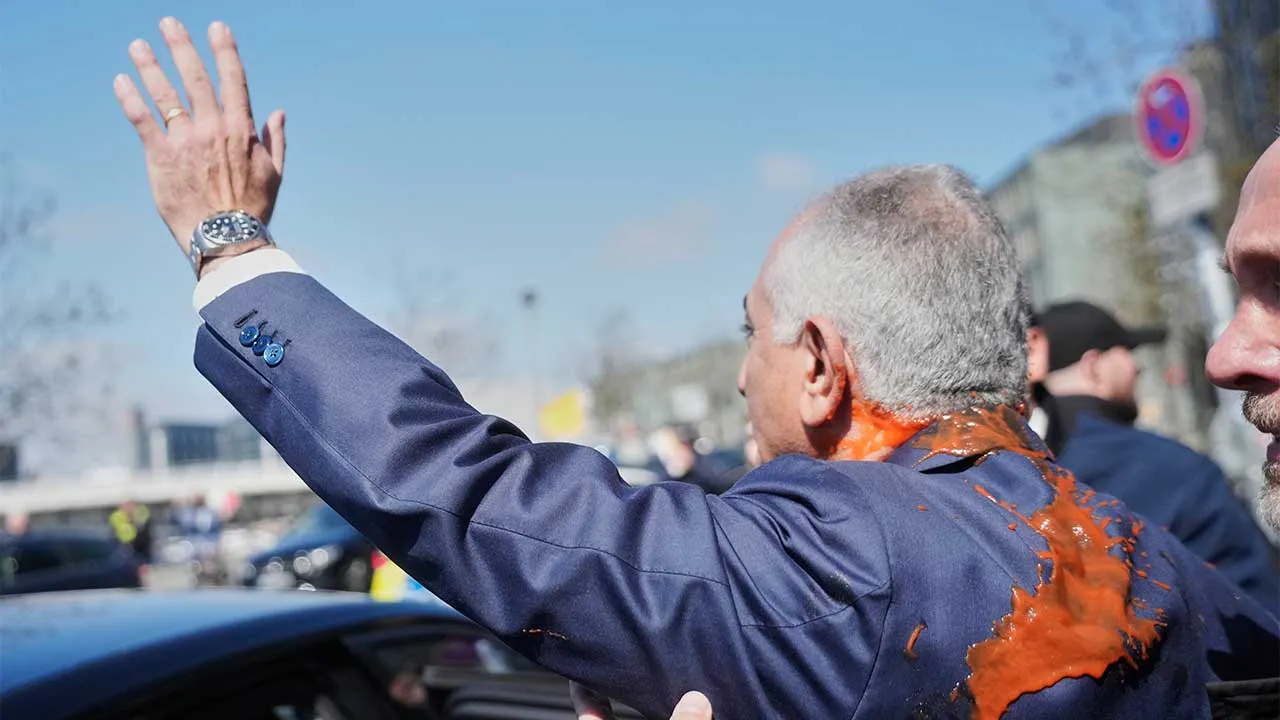 Iran's Reza Pahlavi, exiled son of Shah Reza Pahlavi, waves to supporters after he was attacked with a red fluid following a news conference in Berlin, Germany, Thursday, April 23, 2026. (AP Photo/Markus Schreiber)