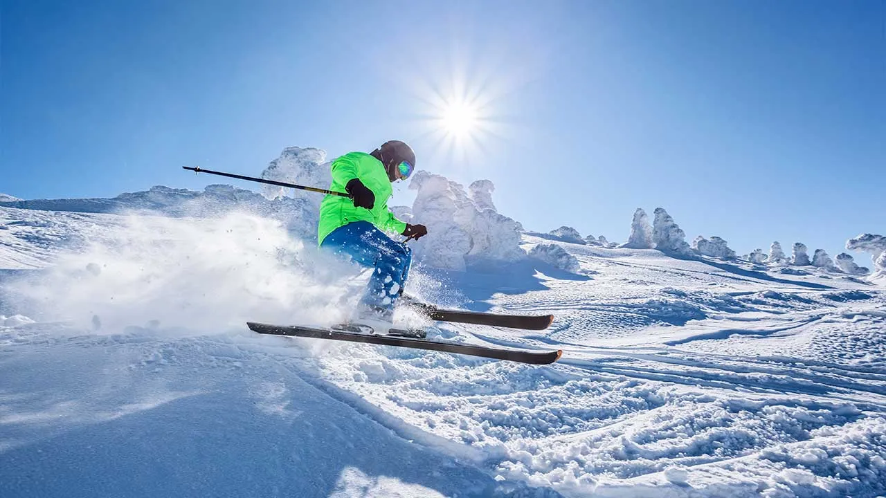 Skier skiing downhill in high mountains against against the fairytale winter forest. By Tomas Marek adobe stock