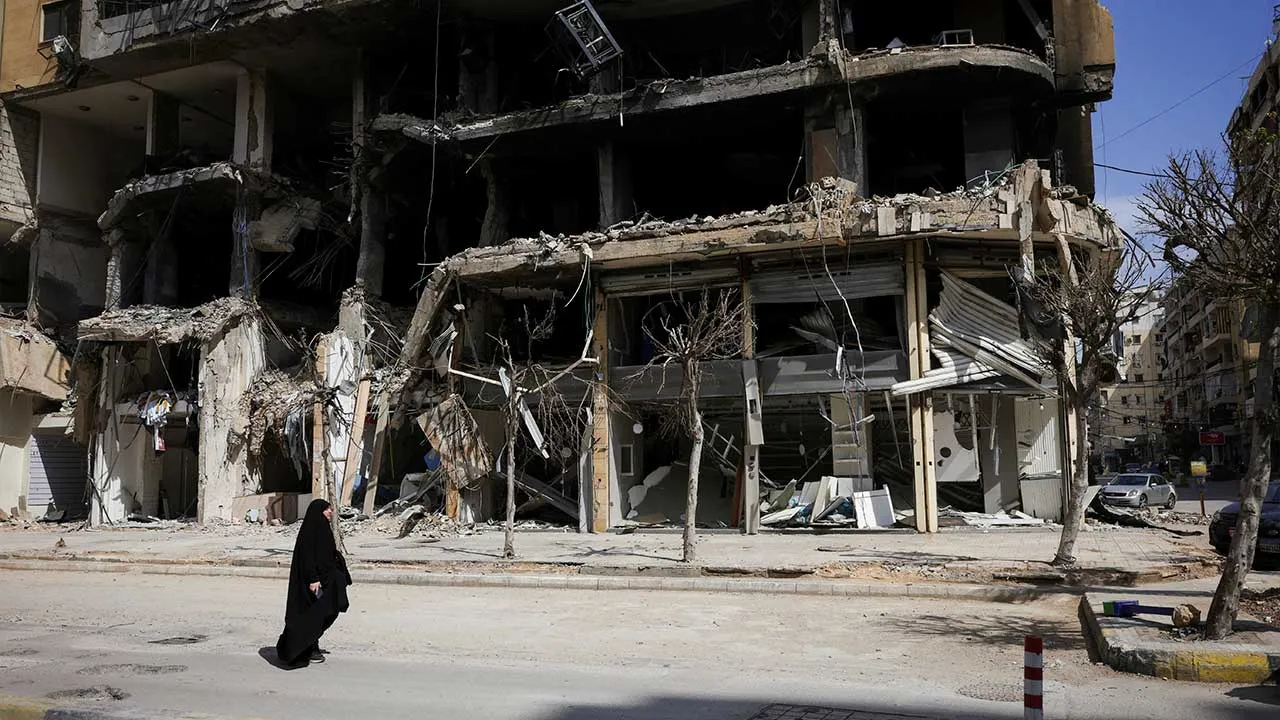A woman walks past damaged buildings amid a 10-day ceasefire between Lebanon and Israel, in the southern suburbs of Beirut, Lebanon, April 20, 2026. REUTERS/Marko Djurica