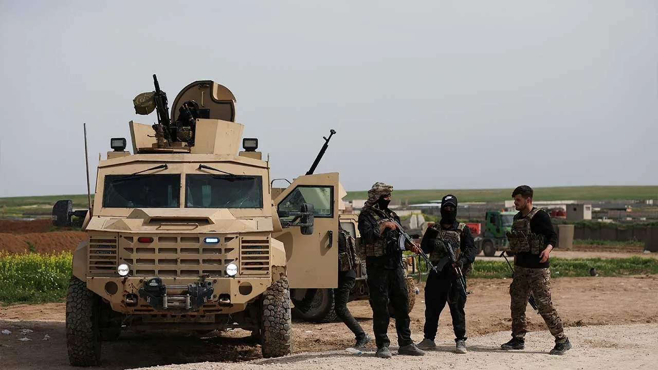 Members of the Syrian Democratic Forces (SDF) stand guard after U.S.-led international coalition forces destroyed their equipment while withdrawing from the Qasrak base, in Hasakah, Syria, April 16, 2026. REUTERS/Orhan Qereman