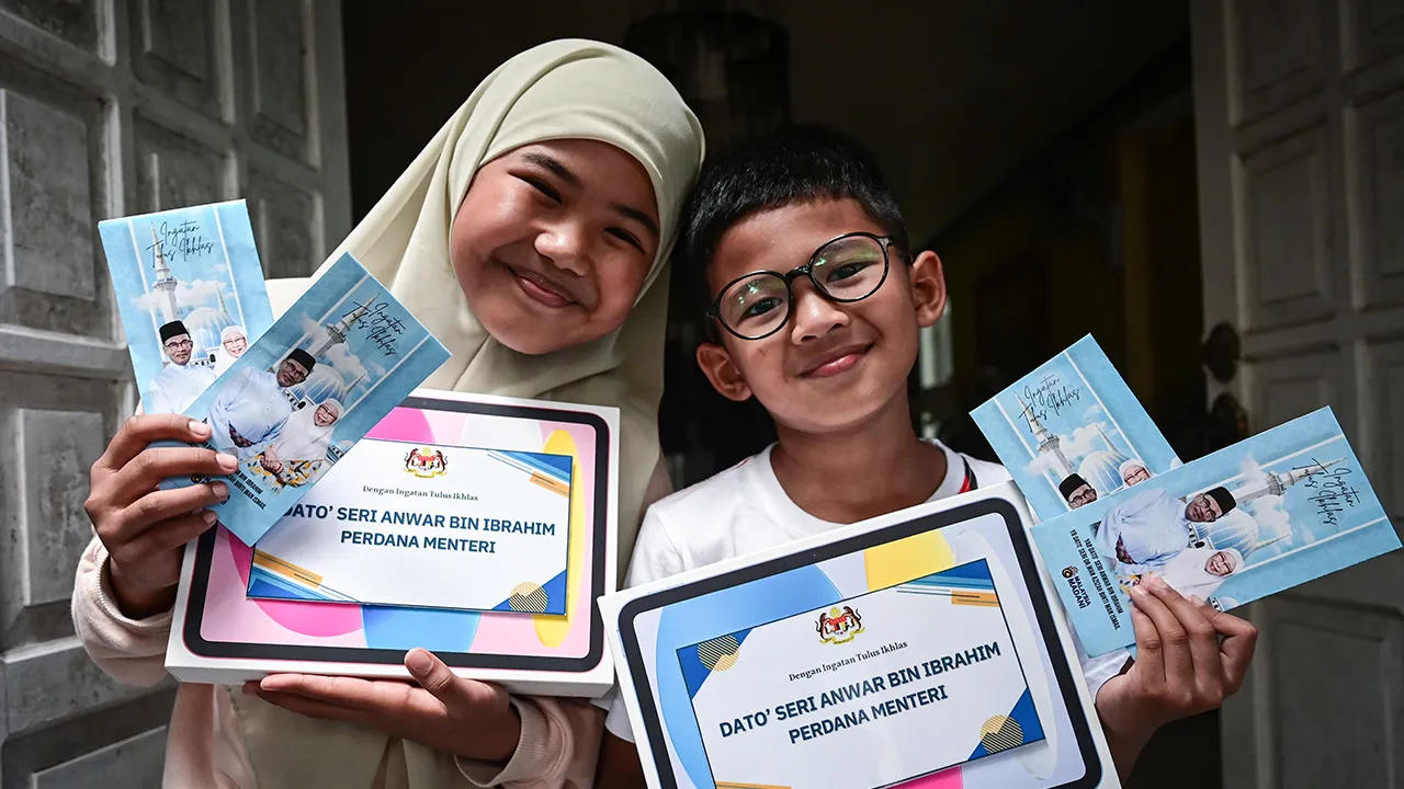 KUALA TERENGGANU, 14 April -- Aesha Khadeeja Anuar,10 (kiri) dan adiknya, Uwais AlQorni Anuar, 8 (kanan) menunjukkan tablet dan duit raya daripada Perdana Menteri Datuk Seri Dr Anwar Ibrahim ketika ditemui di kediaman mereka di Ladang Titian hari ini.  Keikhlasan dua beradik menghadiahkan duit raya kepada Perdana Menteri Datuk Seri Anwar Ibrahim semalam telah menyentuh hati pemimpin negara itu yang membalasnya dengan pemberian sama hari ini.  Aesha Khadeeja berkata dia dan adiknya Uwais AlQorni tidak menyan