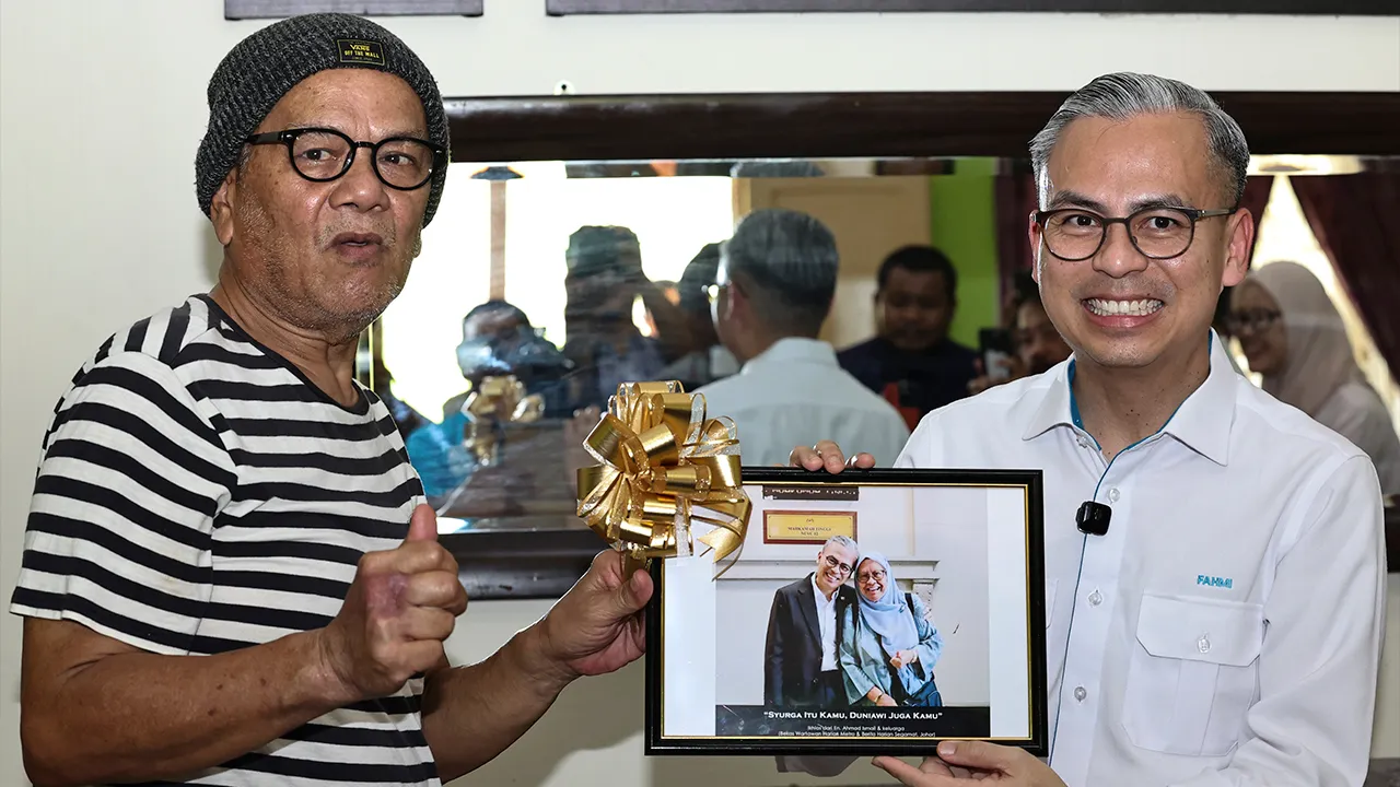 SEGAMAT, 19 April -- Menteri Komunikasi Datuk Fahmi Fadzil (kanan), menerima cenderahati daripada bekas wartawan Harian Metro, Ahmad Ismail selepas menyampaikan sumbangan Tabung Kasih@HAWANA di kediamannya di Kampung Lubuk Batu, hari ini._BERNAMA