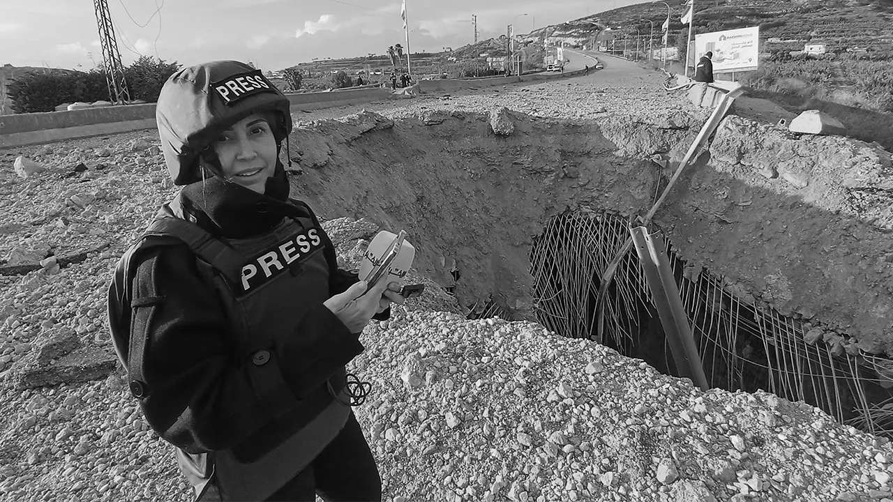 Lebanese journalist Amal Khalil, who works for the daily Al-Akhbar newspaper, reports near a destroyed bridge in Qasmiyeh, Lebanon, Sunday, March 22, 2026. (AP Photo/Mohammed Zaatari)