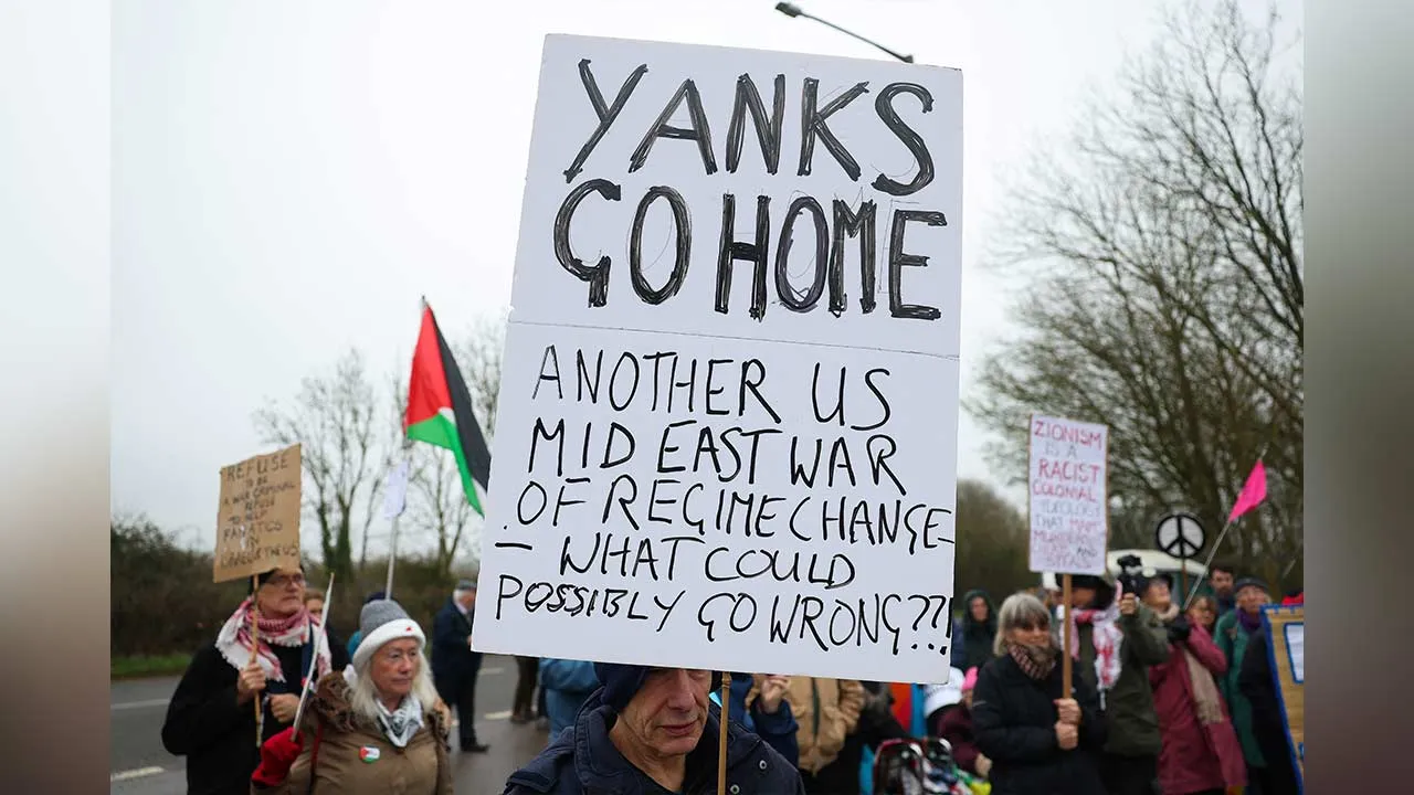 An anti-war activist holds a sign against U.S. involvement in the Middle East, during a protest outside RAF Fairford, which hosts United States Air Force (USAF) personnel, amid the U.S.-Israeli conflict with Iran, in Fairford, Britain, March 7, 2026. REUTERS/Toby Melville