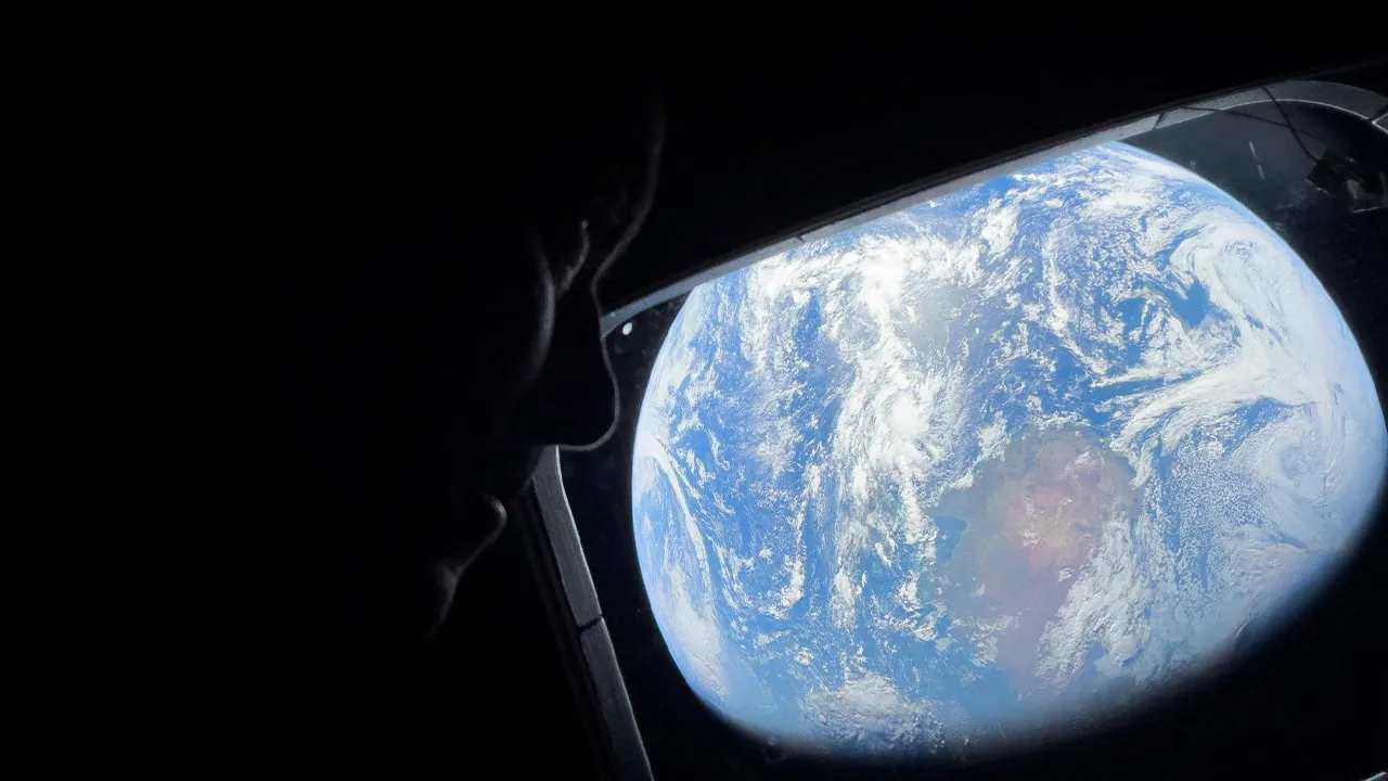 NASA astronaut and Artemis II Commander Reid Wiseman peers out of one of the Orion spacecraft's main cabin windows, looking back at Earth, as the crew travels towards the Moon April 2, 2024. NASA/Handout via REUTERS. THIS IMAGE HAS BEEN SUPPLIED BY A THIRD PARTY.