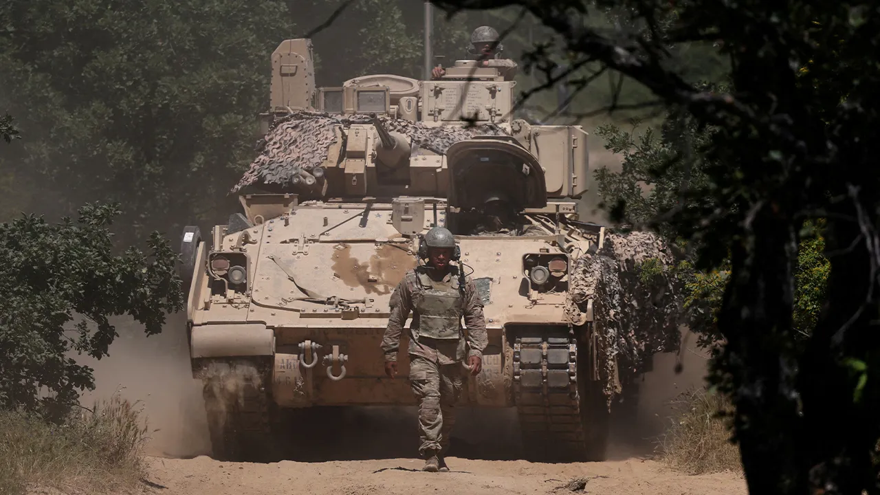 FILE PHOTO: A U.S. soldier walks in front of an armoured vehicle during "Balkan Sentinel - 25" military drill, an exercise involving personnel and equipment from the Bulgarian Land Forces and Air Force, formations from the NATO Multinational Battle Group with Italy, and a mechanized platoon from the Romanian Land Forces, in Koren, Bulgaria, June 9, 2025. REUTERS/Stoyan Nenov/File Photo