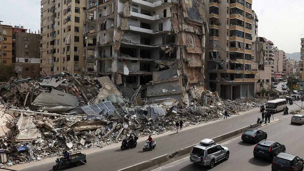 Vehicles drive past damaged buildings as displaced people make their way to return to their homes after a 10-day ceasefire between Lebanon and Israel went into effect, at the southern suburbs of Beirut, Lebanon, April 17, 2026. REUTERS/Mohamed Azakir