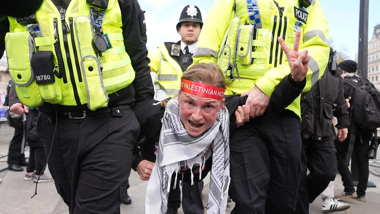 Police remove a protester at a demonstration against the ban on Palestine Action, in Trafalgar Square, central London, Saturday April 11, 2026. (Lucy North/PA via AP)