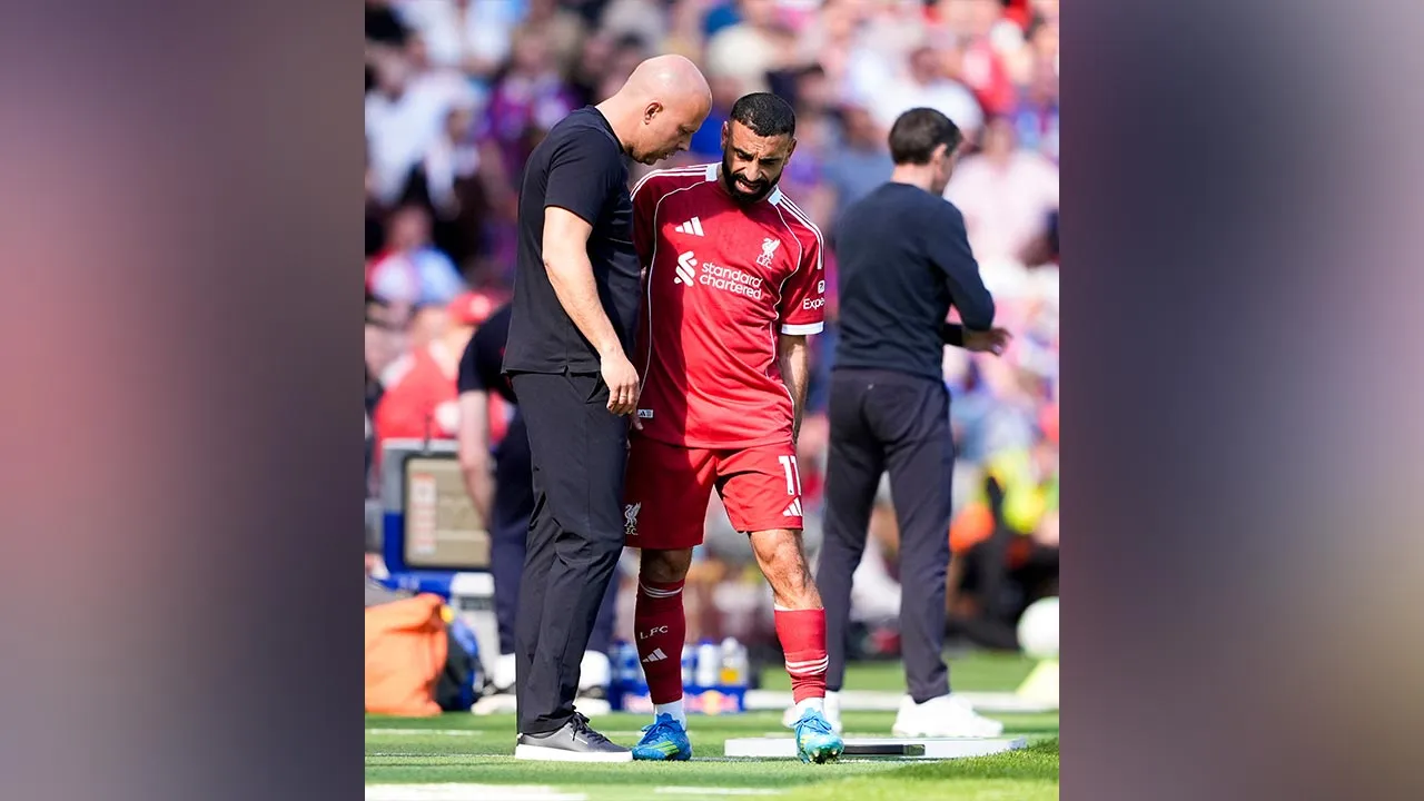 Liverpool's Mohamed Salah grabs at his leg as he speaks with with manager Arne Slot after being substituted during the Premier League soccer match between Liverpool and Crystal Palace, Saturday, April 25, 2026, in Liverpool, England. (Peter Byrne/PA via AP)