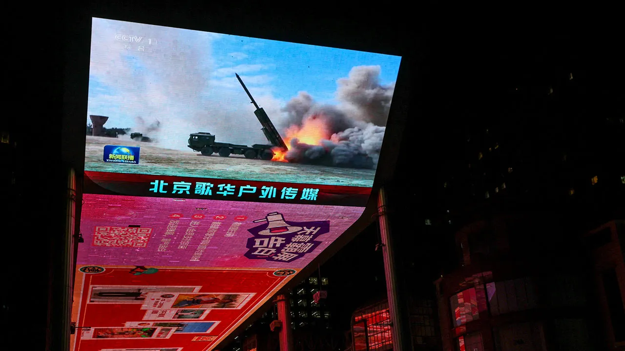 FILE PHOTO: A giant screen shows a news report on China's "Justice Mission 2025" military drills around Taiwan, in Beijing, China December 30, 2025. REUTERS/Tingshu Wang/File Photo