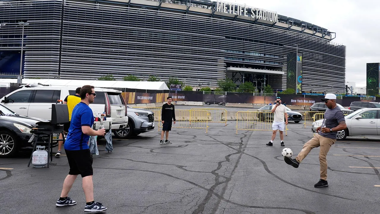 FILE - Fans play with a ball outside the Metlife Stadium prior to the Club World Cup final soccer match between Chelsea and PSG in East Rutherford, N.J., Sunday, July 13, 2025. (AP Photo/Pamela Smith, File)