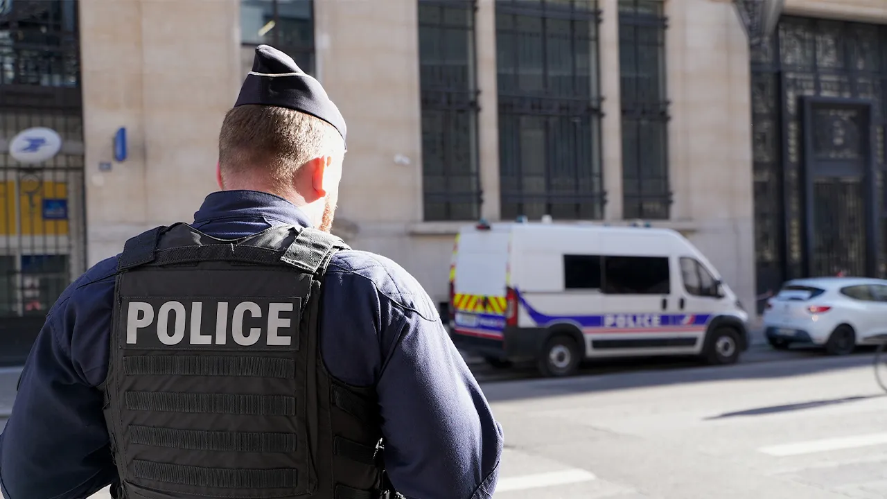 Police stand outside the Bank of America building in Paris, Saturday, March 28, 2026. (AP Photo/Nicolas Garriga)
