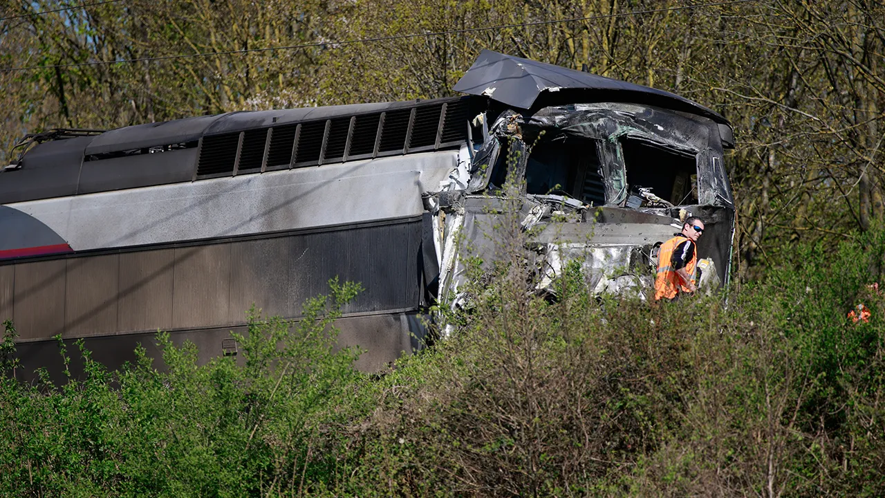 Railway worker stands near a high-speed train (TGV) after it crashed into a truck carrying military equipment in Bully-les-Mines, northern France, Tuesday, April 7, 2026. (AP Photo/Jean-Francois Badias)