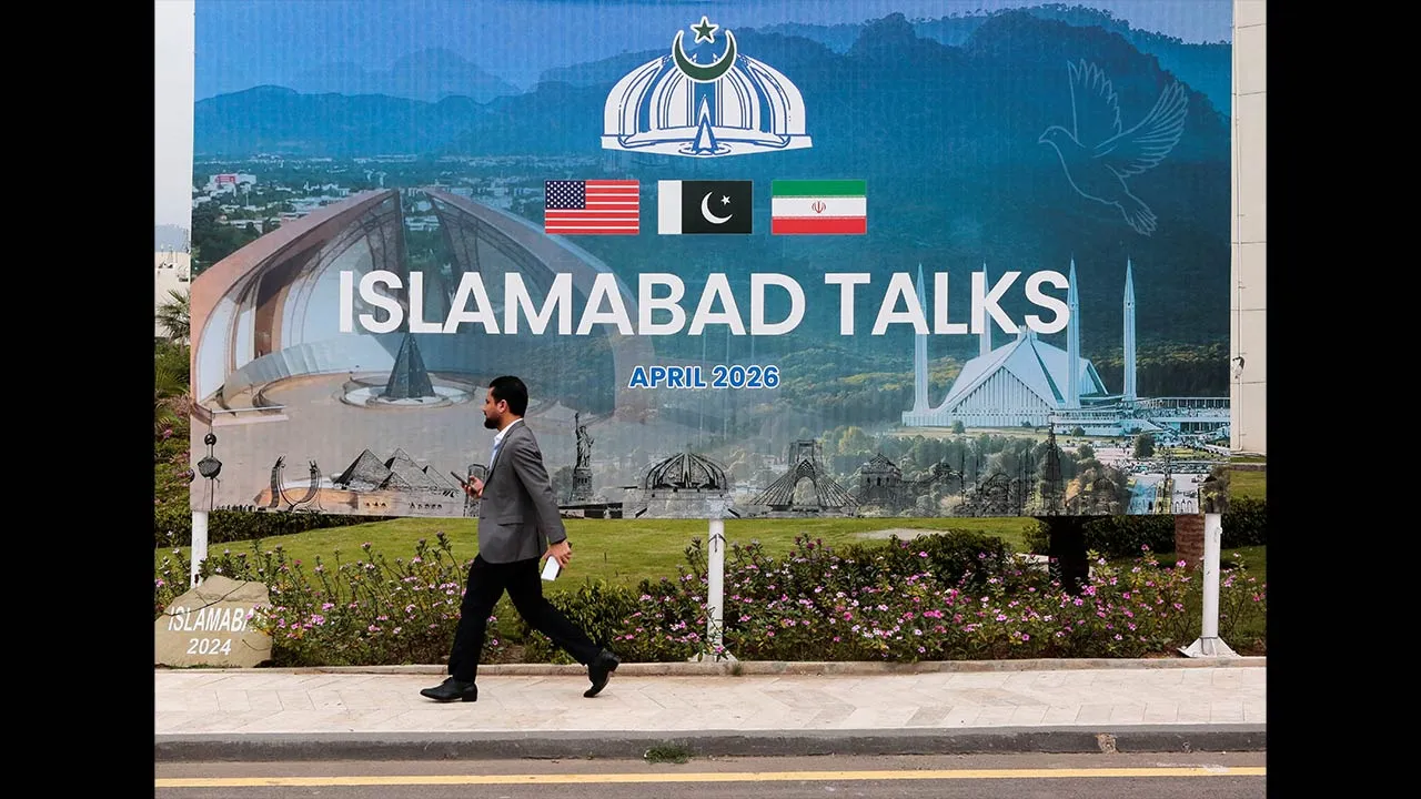 A man walks past a billboard near the media centre as delegations from the United States and Iran are expected to hold high-stakes talks in Islamabad, Pakistan, April 11, 2026. REUTERS/Asim Hafeez