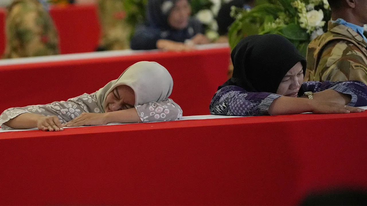Relatives of Indonesian peacekeepers who were killed while serving with the UN Interim Force in Lebanon, weep during an honor ceremony upon the arrival of their bodies at Soekarno-Hatta International Airport in Tangerang, Indonesia, Saturday, April 4, 2026. (AP Photo/Achmad Ibrahim)