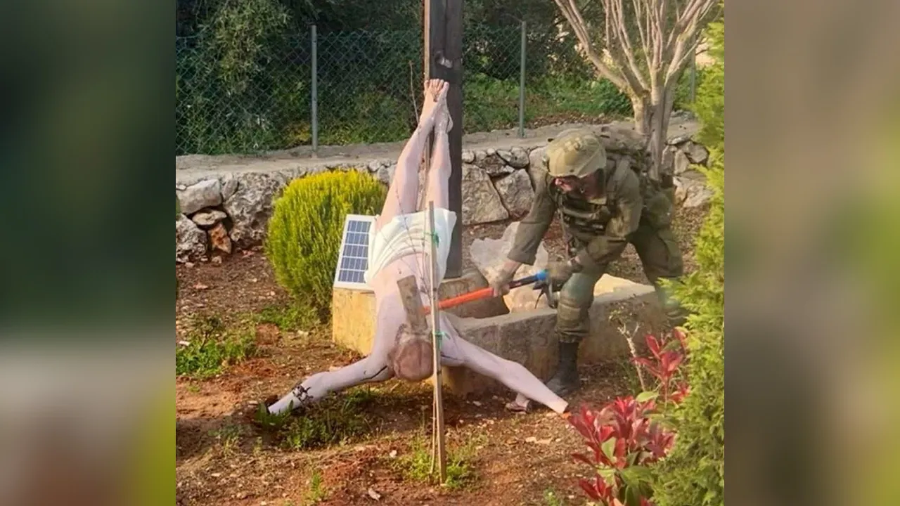FILE PHOTO: An Israeli soldier damages the head of a statue of Jesus, in Debel, Lebanon, in this still image obtained from social media released on April 19, 2026. Social Media/via REUTERS THIS IMAGE HAS BEEN SUPPLIED BY A THIRD PARTY. NO RESALES. NO ARCHIVES. NEWS USE ONLY. VERIFICATION: - Location is verified as Debel, Lebanon as file imagery of the statue tags Debel as the location - Terrain in background also appears to match hills on topography imagery from Debel - Date shot not confirmed but first pos