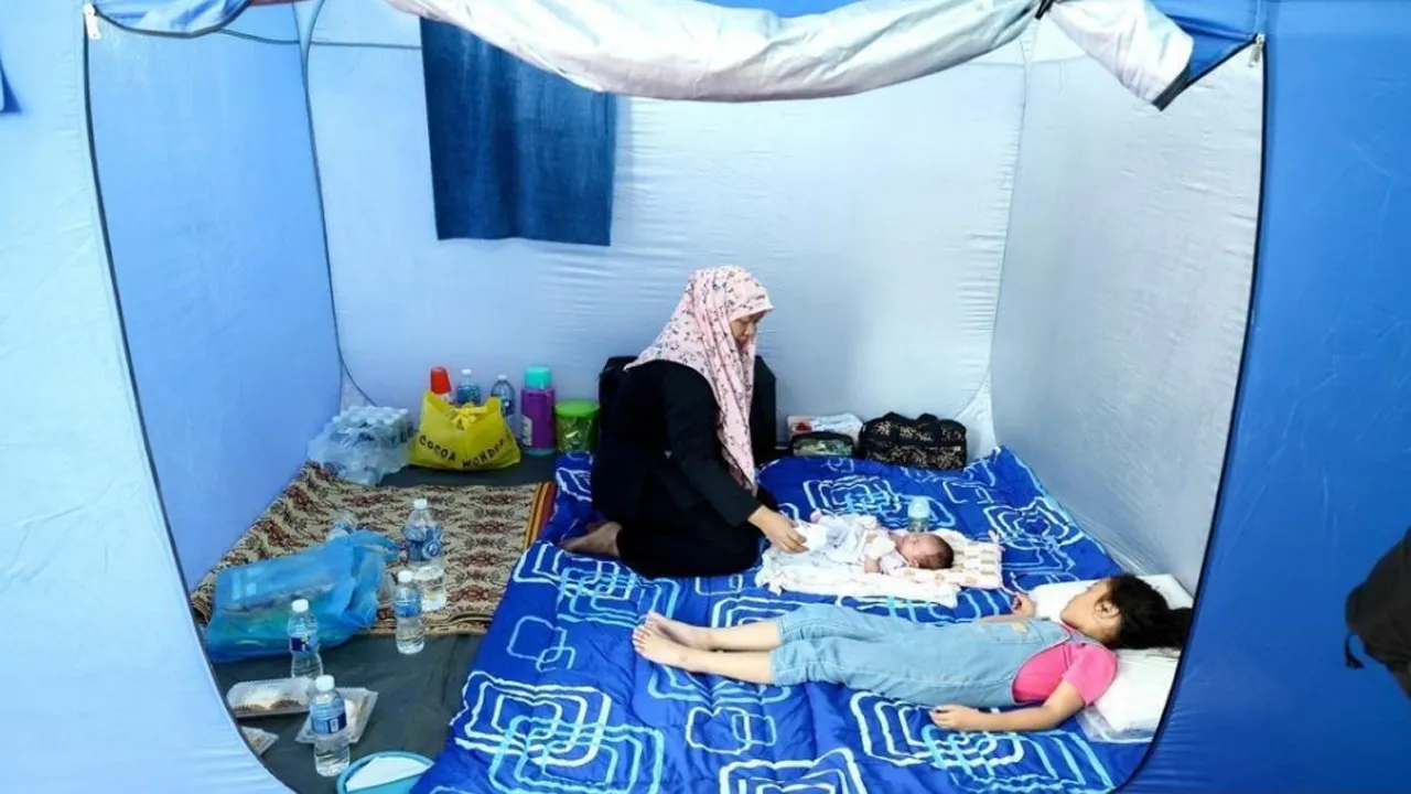 Mangsa kebakaran di perkampungan atas air Kampung Bahagia Nurjaima Kassim menguruskan anaknya Nuraina Munira yang berusia 28 hari di Pusat Pemindahan Sementara (PPS) Dewan Projek Perumahan Rakyat Batu Sapi, Sandakan.
