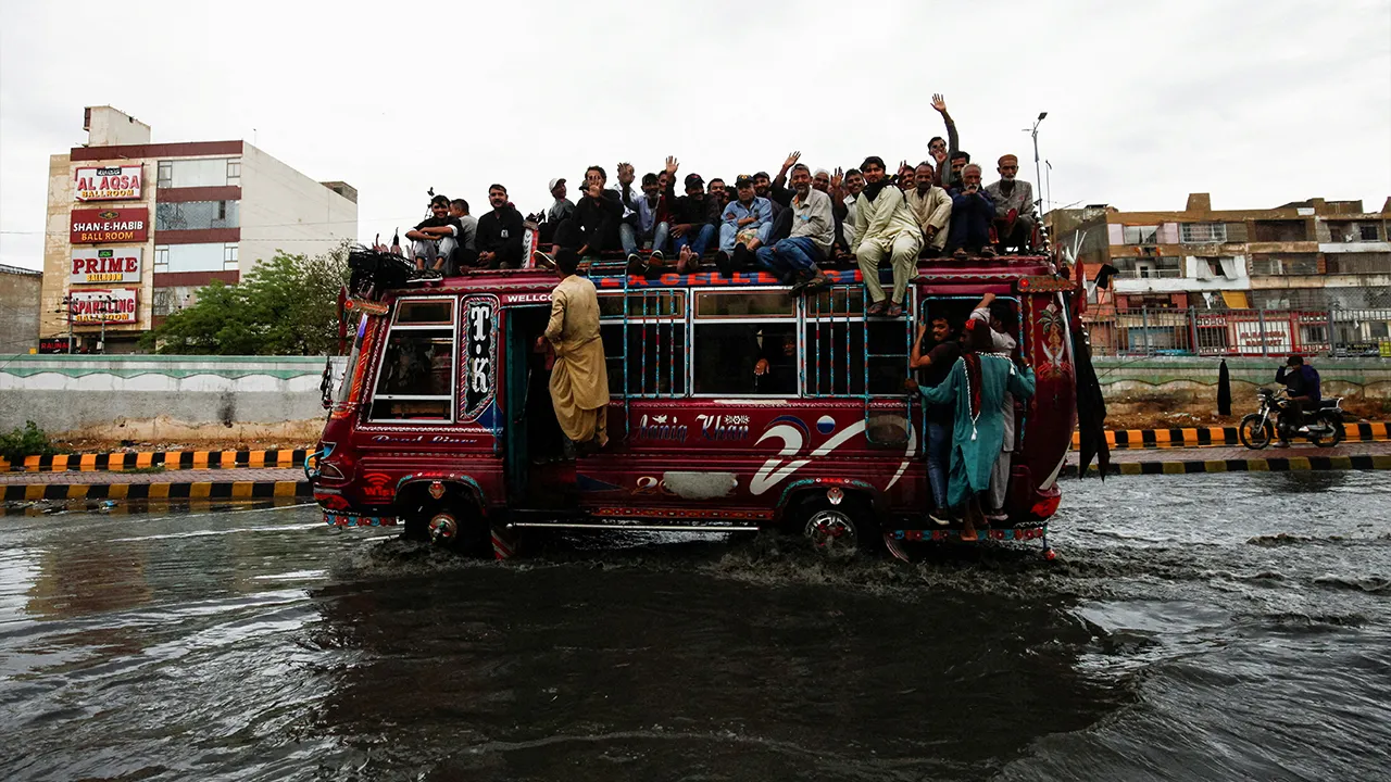Commuters ride in an overcrowded bus along a flooded street following torrential rain in Karachi, Pakistan, April 2, 2026. REUTERS/Qaiser Khan