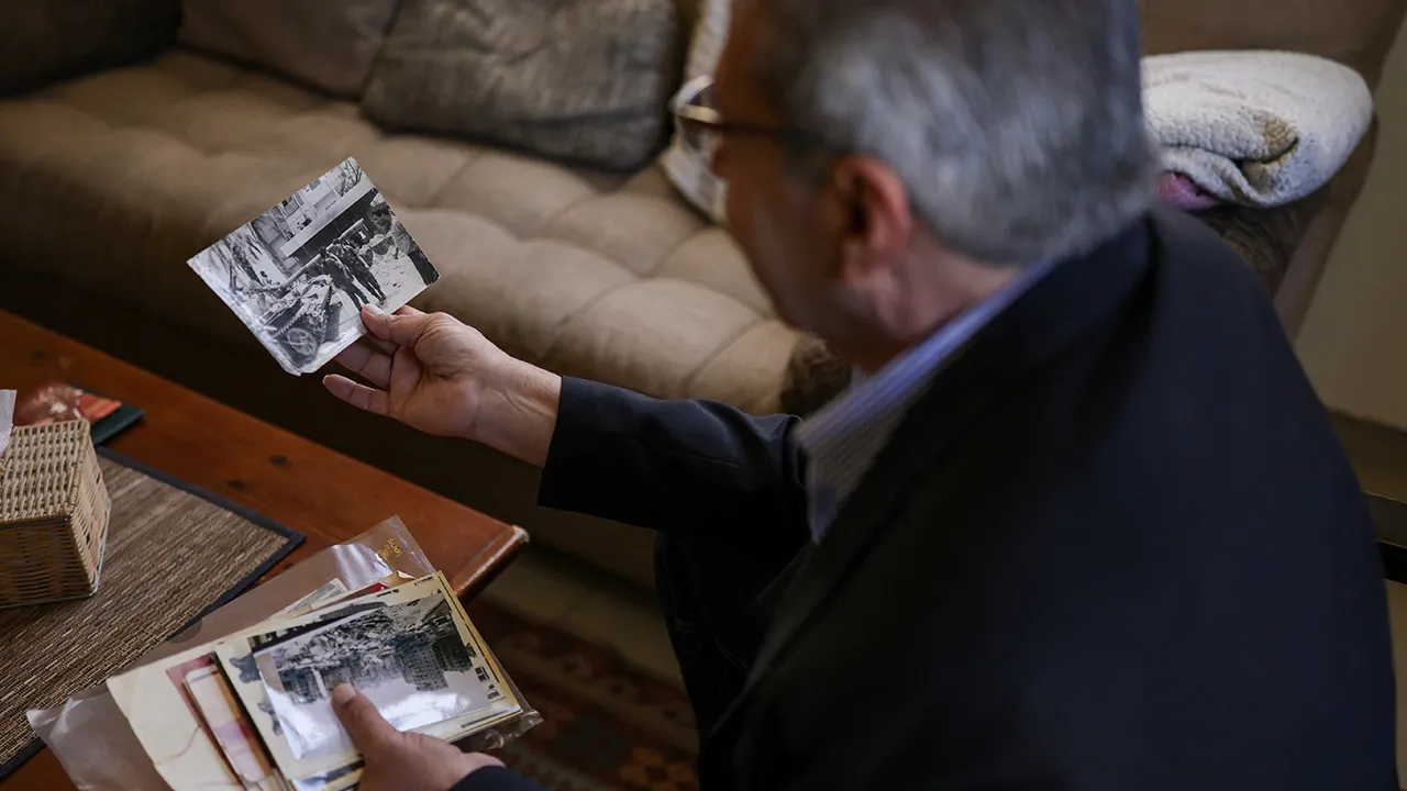 Head of the Lebanese NGO Fighters for Peace Ziad Saab looks at a picture of himself during the Lebanese civil war, in his home in Beirut, Lebanon, April 14, 2026. REUTERS/Emilie Madi