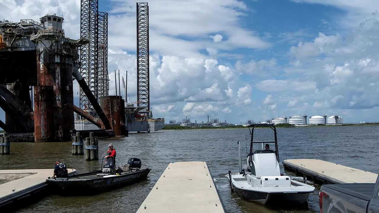 People dock their boats as Cheniere’s Sabine Pass LNG facility, located in Cameron Parish, Louisiana, is seen in the background from Port Arthur, Texas, U.S., on June 23, 2025. REUTERS/Joel Angel Juarez