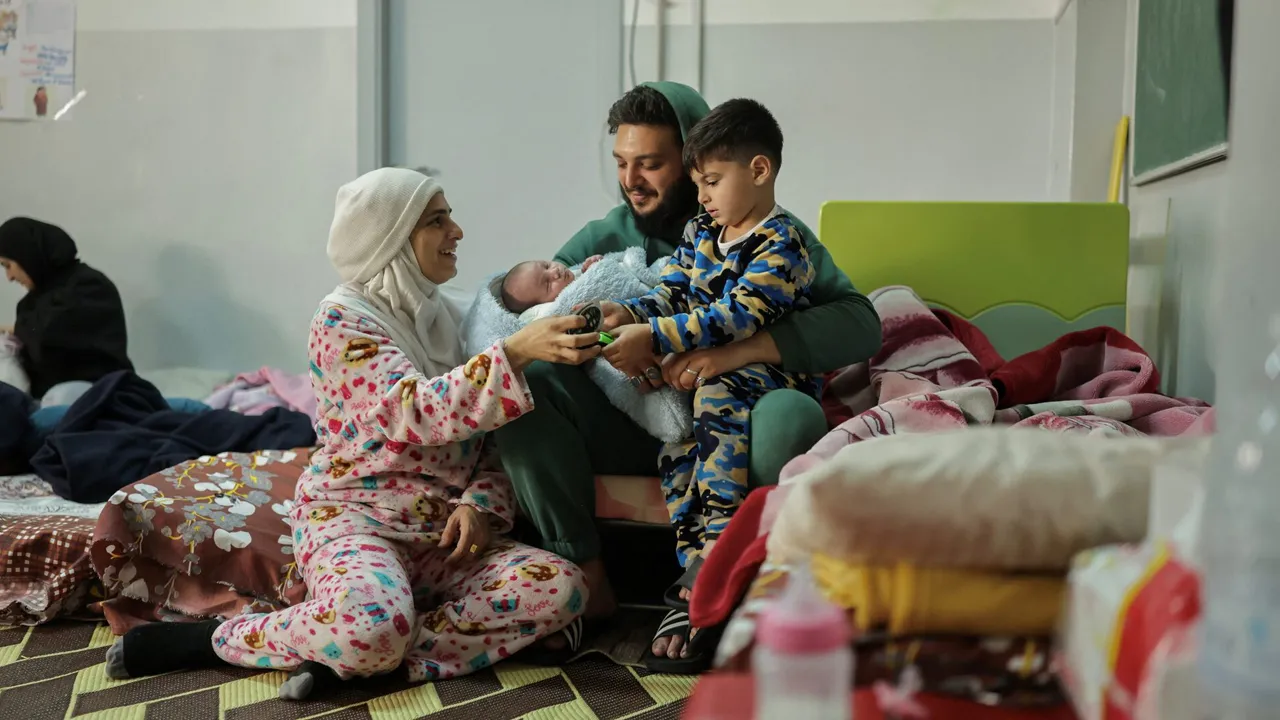 Hawraa Houmani, sits next to her husband Ahmed and their children, Ali and Haidar in a school now used as a temporary shelter for displaced people amid escalating hostilities between Israel and Hezbollah, as the U.S.-Israel conflict with Iran continues, in Beirut, Lebanon, March 27, 2026. REUTERS/Emilie Madi