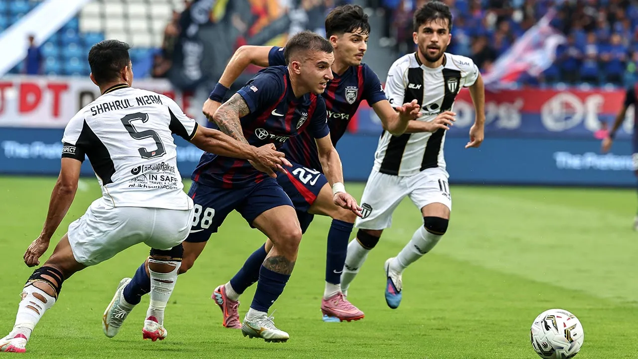 ISKANDAR PUTERI, 11 April -- Pemain JDT, Manuel Federico Hidalgo Gasparini (dua, kiri) diasak pemain Terengganu FC, Muhamad Shahrul Nizam Ros Hasni (kiri), pada perlawanan Liga Super di Stadium Sultan Ibrahim hari ini.  Keputusan semasa, JDT 1 - 1 Terengganu FC.  -- fotoBERNAMA (2026) HAK CIPTA TERPELIHARA