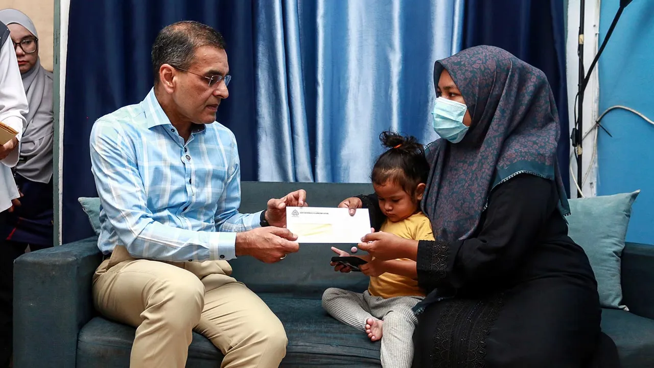 SHAH ALAM, 3 April -- Ketua Pegawai Eksekutif Kumpulan PERKESO Datuk Seri Dr Mohammad Azman Aziz Mohammed menyerahkan Pencen Penakat dan Faedah Pengurusan Mayat (FPM) PERKESO kepada Nor Nadia Abdul Majid (kanan), balu kepada Allahyarham Amirul Hafiz Omar, 33, ketika menziarahi keluarga tersebut di kediamannya hari ini.  -- fotoBERNAMA (2026) HAK CIPTA TERPELIHARA