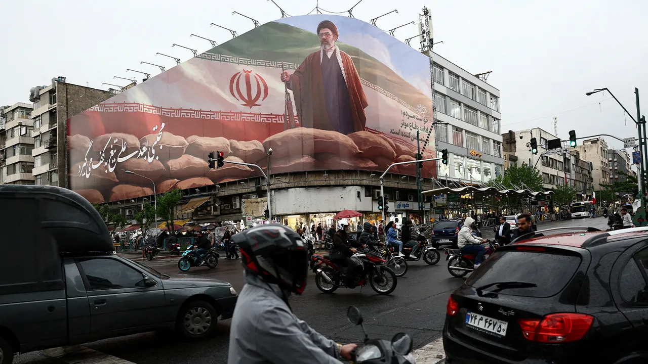 FILE PHOTO: People ride motorcycles near a billboard featuring an image of Iran's new Supreme Leader Mojtaba Khamenei, amid a ceasefire between U.S. and Iran, in Tehran, Iran, April 20, 2026. Majid Asgaripour/WANA (West Asia News Agency) via REUTERS ATTENTION EDITORS - THIS PICTURE WAS PROVIDED BY A THIRD PARTY/File Photo