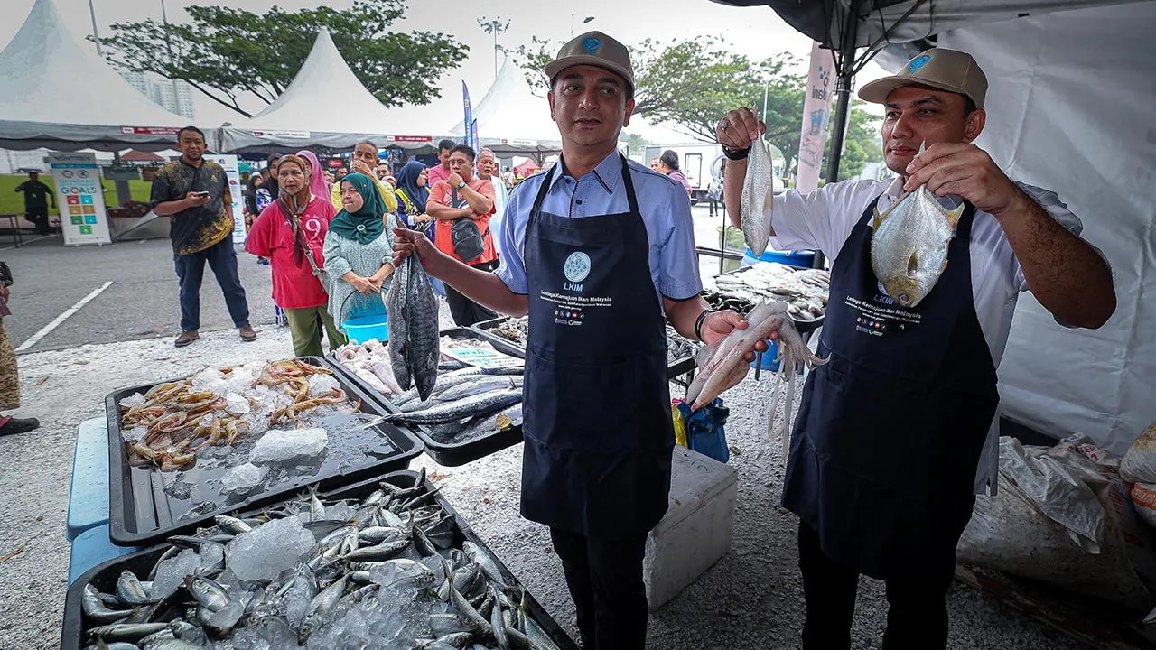 IPOH, 3 April -- Pengerusi Lembaga Kemajuan Ikan Malaysia (LKIM) Muhammad Faiz Fadzil (dua,kanan) menunjukkan hasil laut pada sesi Jualan Ikan Segar LKIM sempena Program Madani Rakyat (PMR) 2026 di Bulatan Sultan Azlan Shah Meru hari ini.   --fotoBERNAMA (2026) HAK CIPTA TERPELIHARA