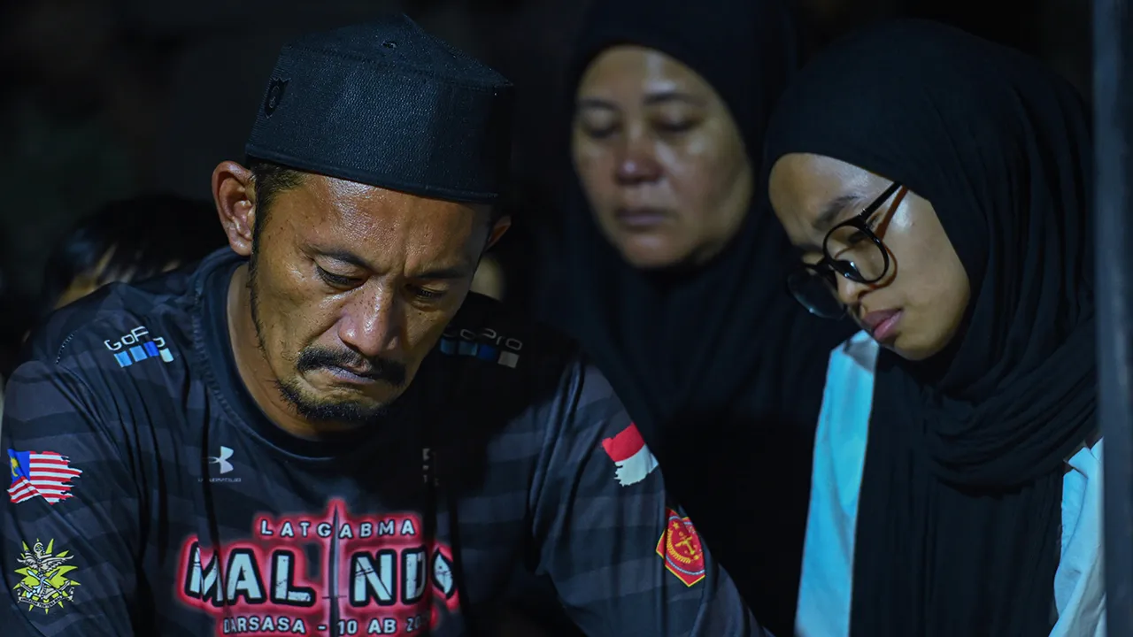 TAMPIN, 12 April -- Rosafindi Tambi Chik (kiri) bapa kepada Allahyarham Muhammad Amirul Raziq kelihatan sugul sejurus selesai pengebumian anaknya di Tanah Perkuburan Felda Sungai Kelamah, Gemas, malam tadi.  Prebet dari Unit Batalion 25 Rejimen Askar Melayu Diraja (RAMD) Bentong, Muhammad Amirul Raziq, 24, meninggal dunia selepas koma akibat kecederaan dipercayai dipukul._BERNAMA