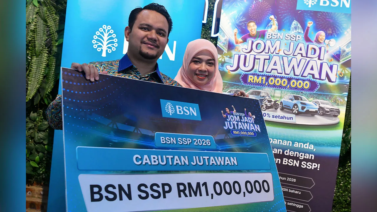 KOTA BHARU, 16 April -- Pegawai Tadbir Negeri Kelantan Muhammad Riyadhul Hanif Abdullah, 34, (kiri) ditemani isteri Zarifah Zulkepli, 33, (kanan) bergambar dengan replika cek selepas dinobatkan sebagai pemenang cabutan Jutawan Bank Simpanan Nasional Sijil Simpanan Premium (BSN SSP) pada Program Temu Ramah Media Bersama Pemenang BSN SSP Ke-122 hari ini.  --fotoBERNAMA