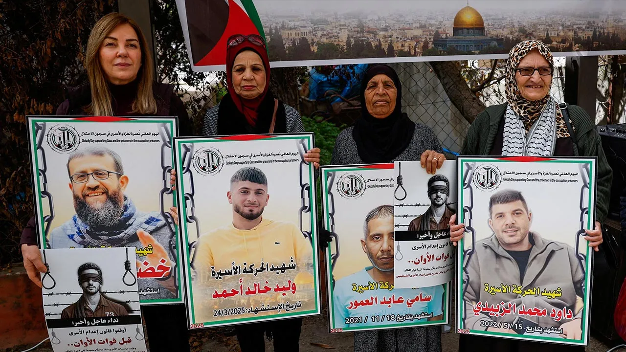 Palestinians hold placards as they take part in a protest against the execution of the Israeli death penalty law for Palestinians convicted of lethal attacks, in Ramallah in the Israeli-occupied West Bank, March 31, 2026. REUTERS/Mohammed Torokman