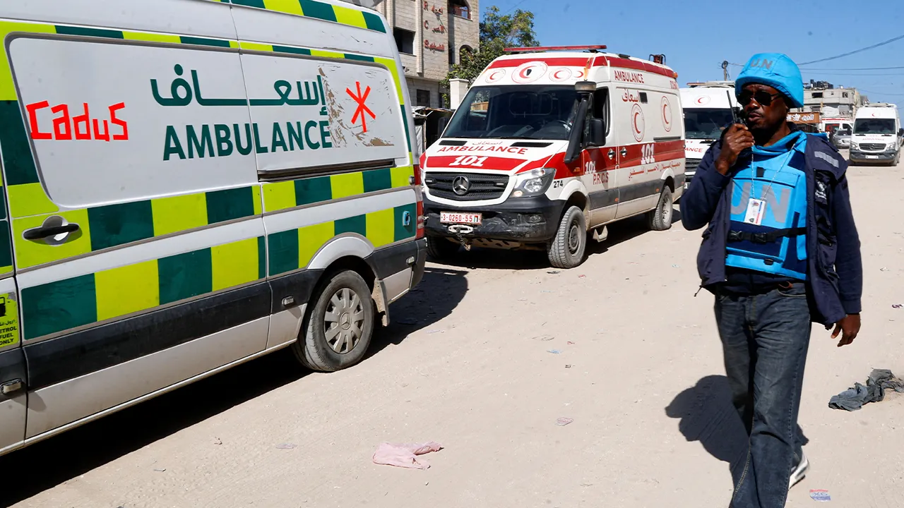 A UN worker walks alongside a convoy carrying wounded Palestinians as they leave Gaza for treatment through the Rafah border crossing between Gaza and Egypt after it was reopened by Israel on Sunday for a limited number of people, in Khan Younis, southern Gaza Strip, April 12, 2026. REUTERS/Haseeb Alwazeer