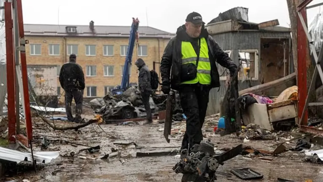 An investigator collects debris of a Russian drone at the impact site in a residential neighborhood, amid Russia's attack on Ukraine, in Vyshneve, outside Kyiv on Apr 3, 2026. (Photo: Reuters/Thomas Peter)
