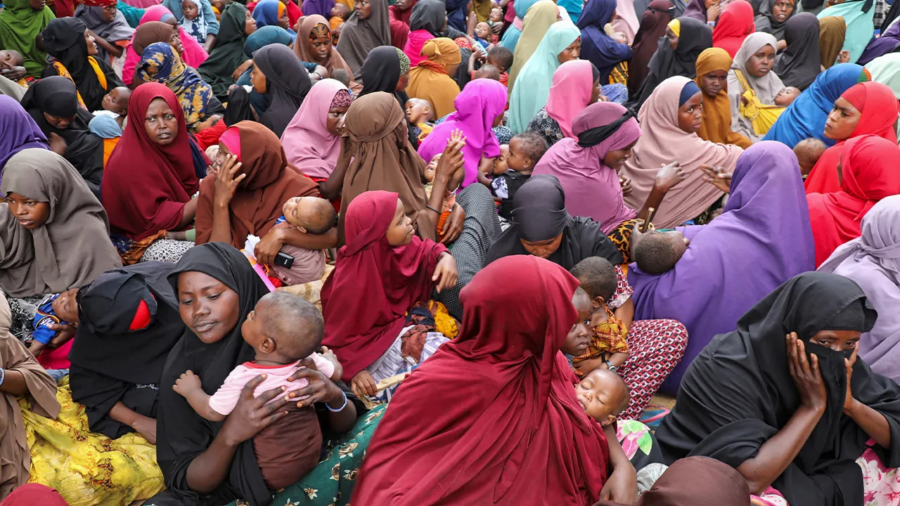 Internally displaced Somali women carry their children during a visit by United Nations (UN) Under-Secretary-General for Humanitarian Affairs and Emergency Relief Coordinator Tom Fletcher (not pictured), as shortages of lifesaving therapeutic foods caused by shipping disruptions due to the Iran war have forced clinics treating severely malnourished children to turn away patients and ration supplies in drought-hit Somalia, at a camp on the outskirts of Mogadishu, Somalia April 28, 2026. REUTERS/Feisal Omar