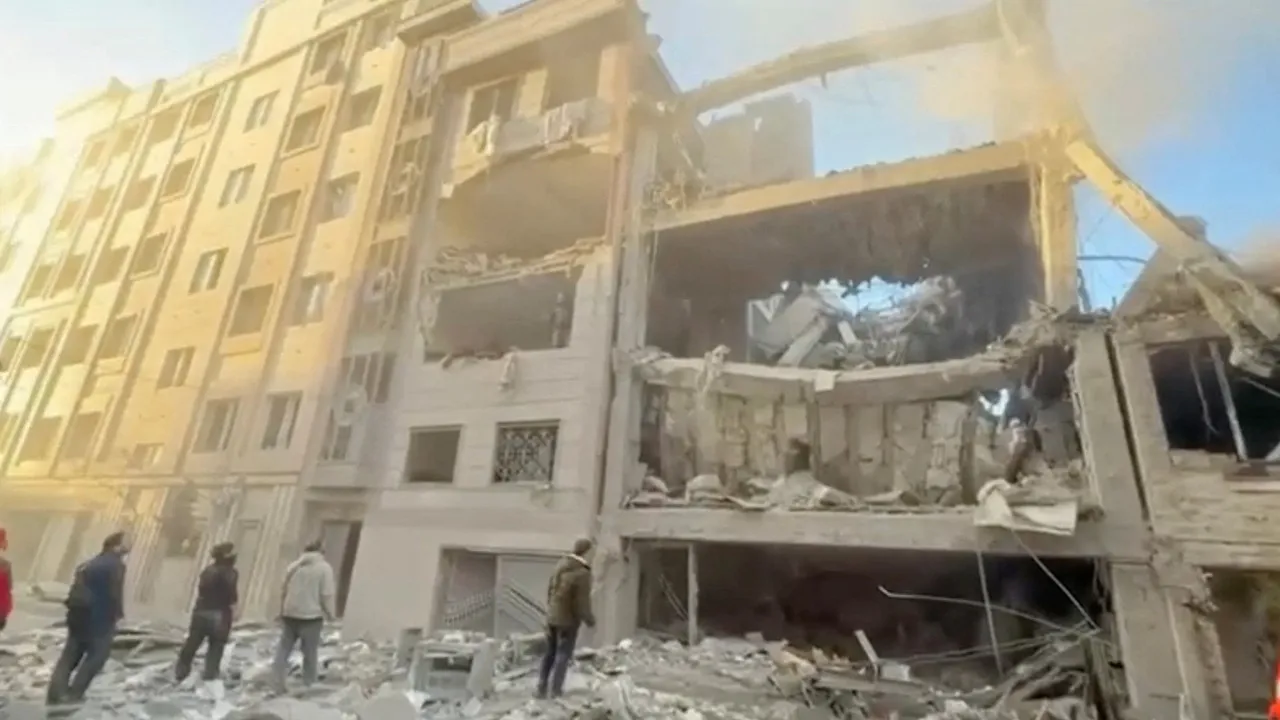 People stand near damaged buildings, amid the U.S.-Israeli conflict with Iran, in Tehran, Iran, in this still image obtained from a handout video released on April 1, 2026. Iranian Red Crescent Society/Handout via REUTERS
