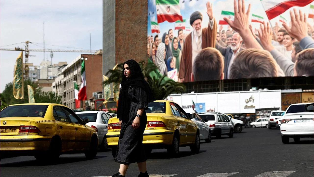 FILE PHOTO: A woman walks past a billboard featuring an image of the late Supreme Leader of Iran, Ayatollah Ali Khamenei, on a building, amid a ceasefire between U.S. and Iran, in Tehran, Iran, April 27, 2026. Majid Asgaripour/WANA (West Asia News Agency) via REUTERS ATTENTION EDITORS - THIS PICTURE WAS PROVIDED BY A THIRD PARTY/File Photo