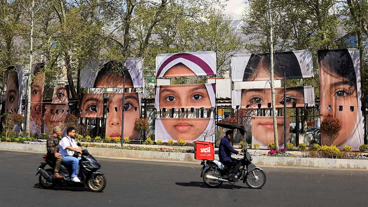 People on motorcycles ride along a street past banners showing portraits of students killed in a strike on a girls’ school during the U.S.-Israeli conflict with Iran, amid a ceasefire, at Tajrish Square in Tehran, Iran, April 15, 2026. REUTERS/Thaier Al-Sudani Foreign media in Iran operate under guidelines set by the Ministry of Culture and Islamic Guidance, which regulates press activity and permissions. TPX IMAGES OF THE DAY