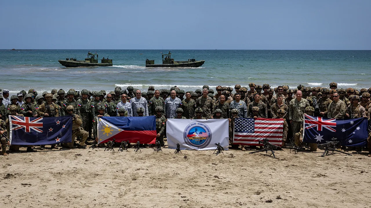 Troops from New Zealand, Philippines, U.S., and Australia pose for a photo with their national flags after participating in counter-landing live fire exercises during Balikatan, the annual joint military exercises between the U.S. and the Philippines, at Long Point Beach, Brgy. Aporawan, Aborlan, Palawan, Philippines, April 27, 2026. REUTERS/Eloisa Lopez