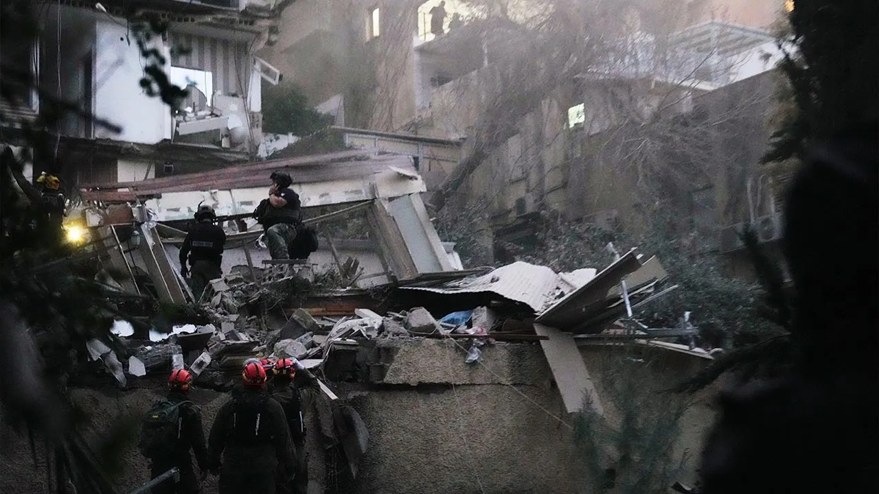 Israeli security forces and rescue teams work amid the rubble of a residential building struck by an Iranian missile in Haifa, Israel, Sunday, April 5, 2026. (AP Photo/Ariel Schalit)