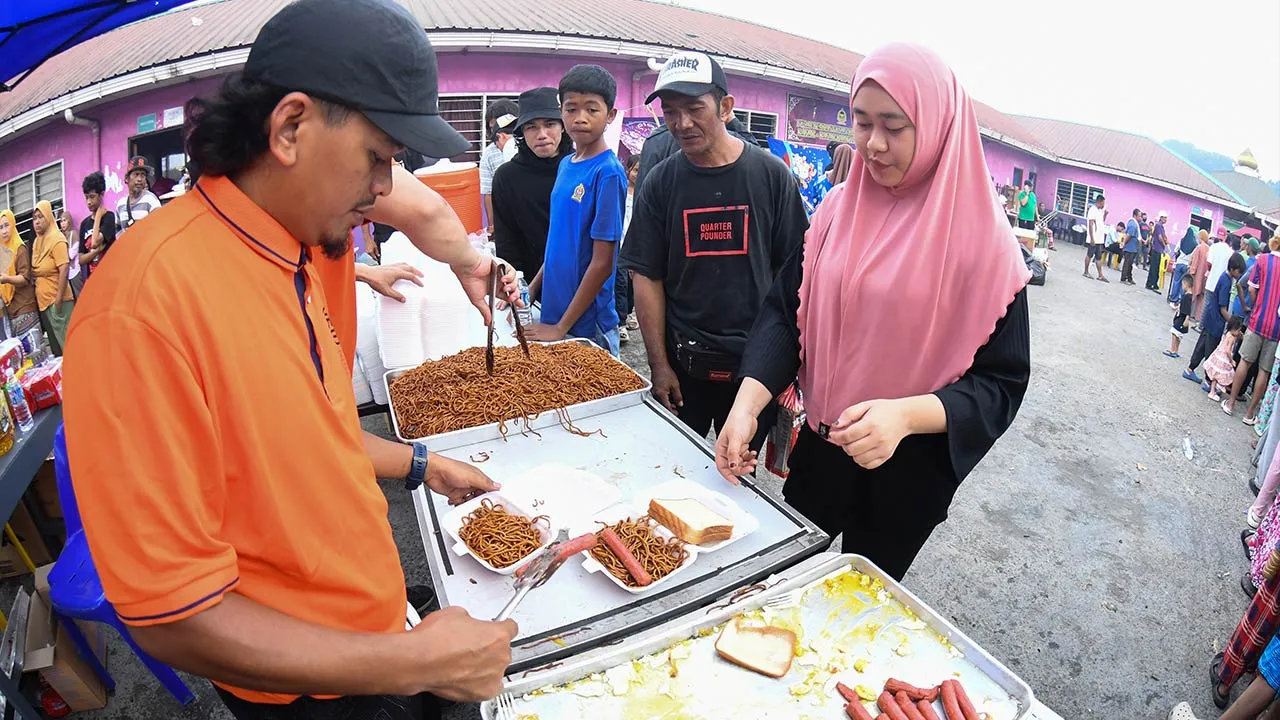 SANDAKAN, 21 April -- Wakil Pertubuhan Bukan Kerajaan (NGO) Mohamad Kadir Abdul Jalil (kiri) mengedarkan makanan kepada mangsa di tapak kebakaran ketika tinjauan di Kampung Bahagia hari ini._BERNAMA