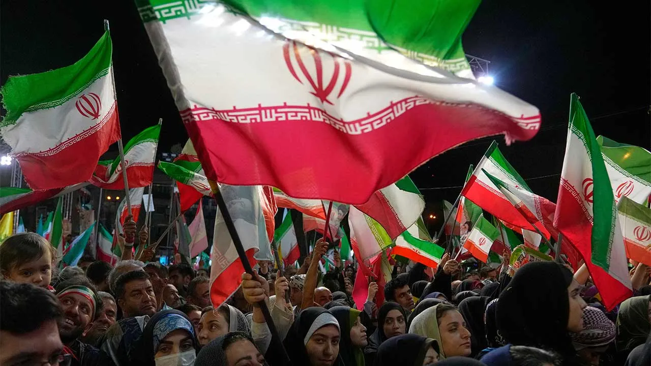 Government supporters wave Iranian flags in a pro-government gathering at Islamic Revolution Square in Tehran, Iran, Wednesday, May 13, 2026. (AP Photo/Vahid Salemi)