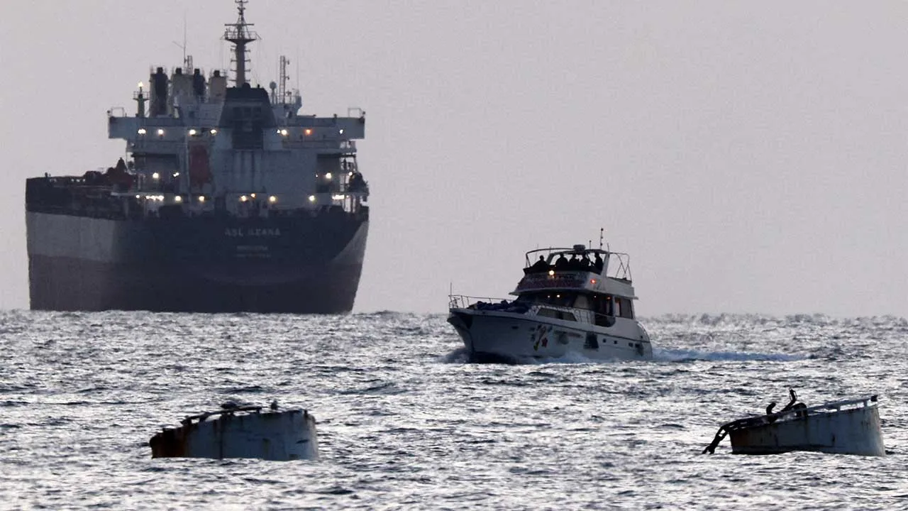 Israeli soldiers are seen on a vessel bearing symbols of the Global Sumud Flotilla, with a cargo ship behind it, as seen from Ashdod, southern Israel, May 19, 2026. REUTERS/Amir Cohen TPX IMAGES OF THE DAY