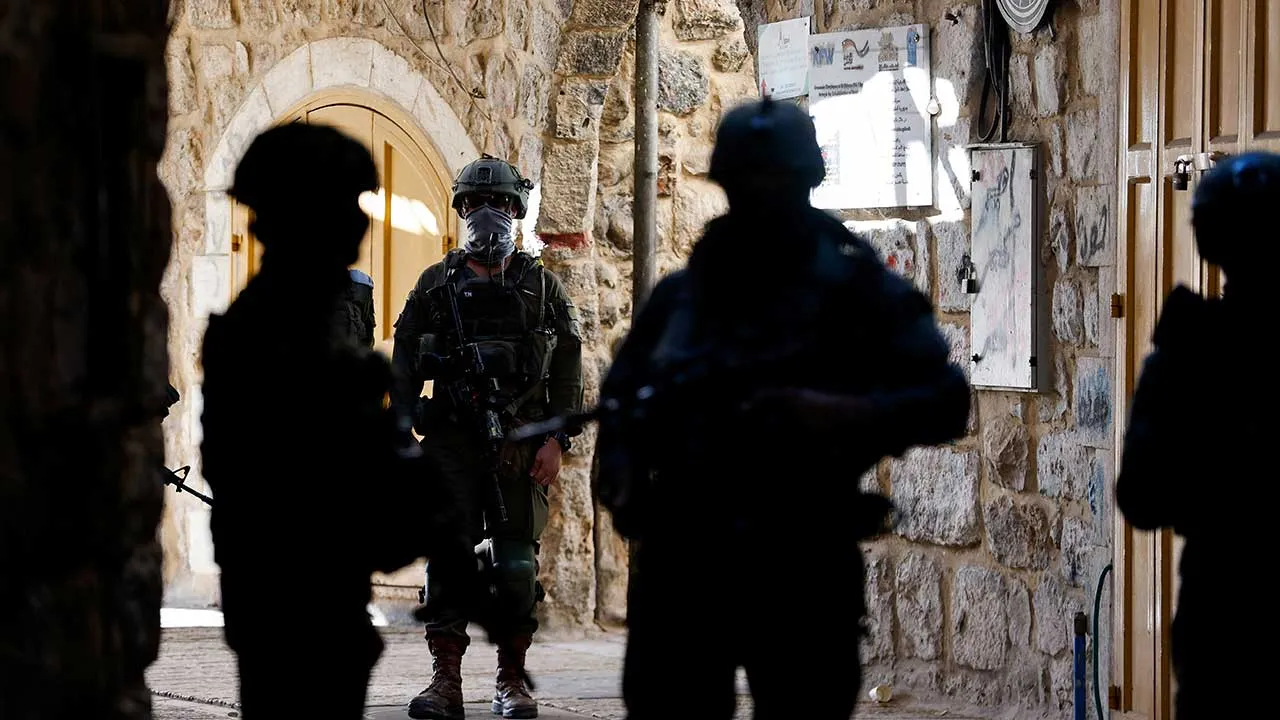 Israeli soldiers stand guard during a weekly settlers' tour in Hebron, in the Israeli-occupied West Bank, May 16, 2026. REUTERS/Mussa Qawasma